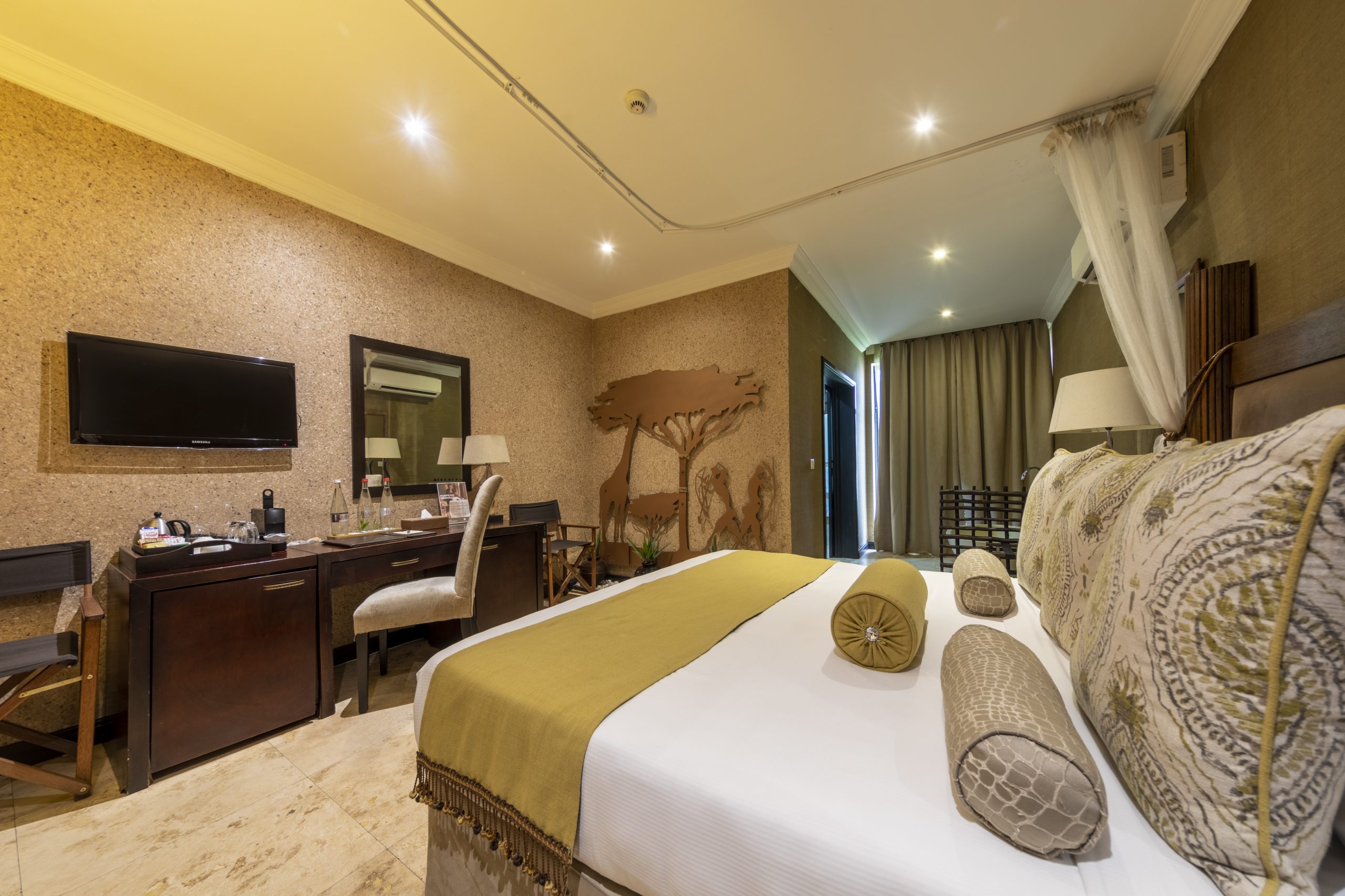 Londolozi Junior Suite showcasing elegant furnishings, natural decor, and large windows that offer stunning views of the surrounding wilderness, creating a cozy and inviting atmosphere.