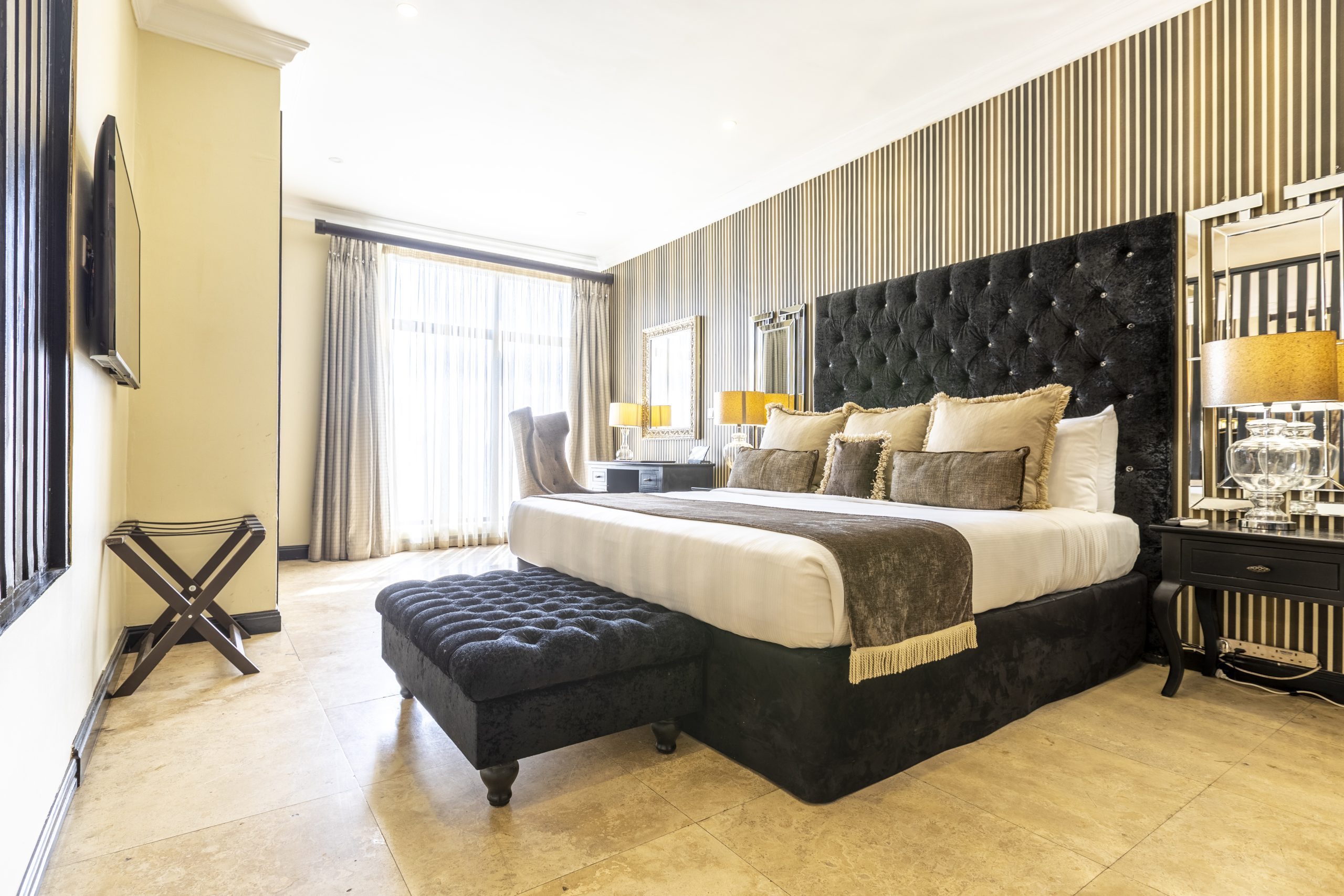 Nelson Mandela Presidential Suite bedside featuring elegant furnishings, soft lighting, and tasteful decor, creating a luxurious and inviting atmosphere for rest and relaxation.