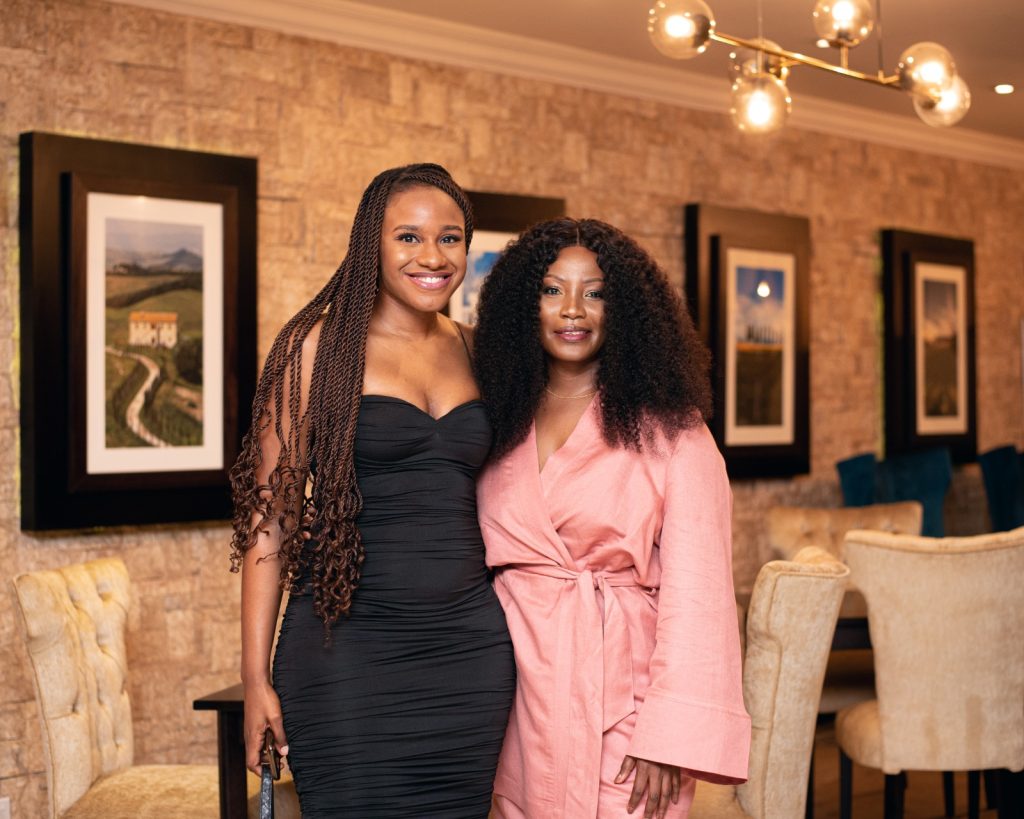 Two girls smiling and posing closely together, showcasing their joyful expressions and similar features.